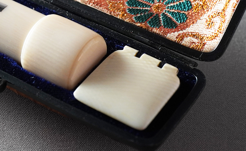 KFケースに収めた鞘付きの象牙の印鑑と、象牙の肉池の蓋「牙蓋」